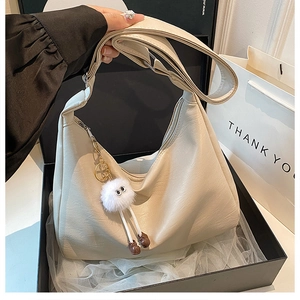 Chic cream hobo bag in a gift box with a plush charm and wide adjustable strap