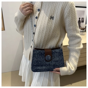Détail du sac bandoulière en denim avec strass argentés et rabat en cuir marron
