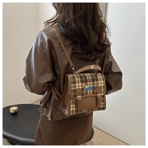 Close-up of vintage brown plaid backpack with cute dachshund embroidery on the flap