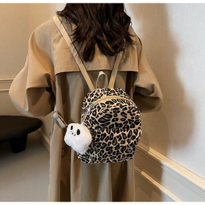 Dettaglio mini zaino leopardato in tela con ciondolo a forma di panda in peluche bianco