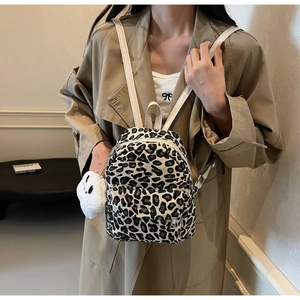 Mini zaino leopardato indossato con ciondolo a nuvola di peluche e spallacci in pelle