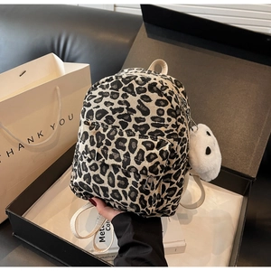 Dettaglio di un mini zaino leopardato in una scatola regalo nera con ciondolo a panda