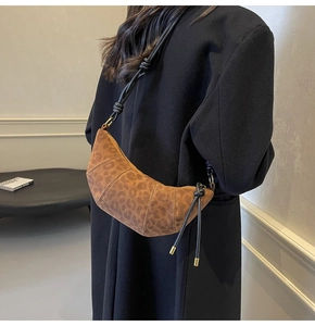 Detailed view of the leopard print croissant bag with a black knotted shoulder strap