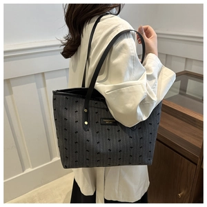 Détail du sac cabas en tissu gris avec rayures verticales, nœud et anses en cuir