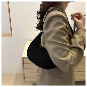 Side view of black crocodile pattern hobo bag with gold hardware worn by model