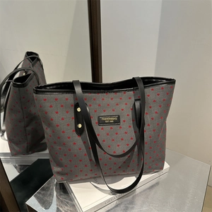 Chic grey tote bag with red heart pattern and long black leather handles for women