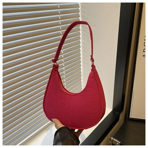 Detail of rose pink crescent bag featuring faux crocodile texture and metallic buckle