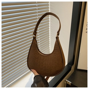 Close-up of brown crocodile texture crescent bag with gold-tone zipper detail