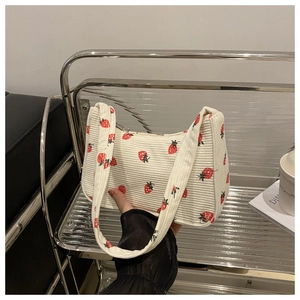 Gros plan du sac porté épaule en velours côtelé blanc cassé avec imprimés fraises