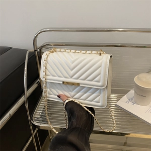 Gesteppte weiße Kettenschultertasche mit goldener Hardware in einem luxuriösen Interieur
