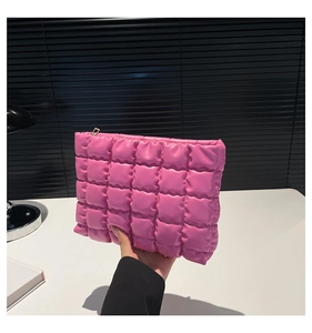 Dettaglio della borsa da trucco rosa trapuntata con trama a quadretti e chiusura lampo