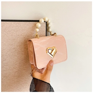 Detail of pink marble textured mini bag with pearl handle and golden heart lock