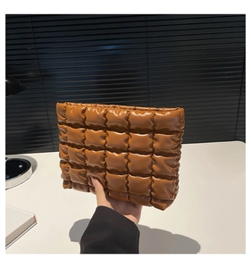 Dettaglio della borsa imbottita marrone che mostra la texture trapuntata e i quadretti