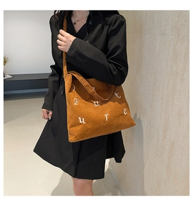 Détail du sac cabas en velours côtelé avec broderie Future blanche et texture douce au toucher