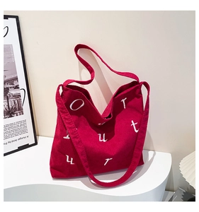 Gros plan sur le sac fourre-tout en velours côtelé rouge avec broderie blanche chic