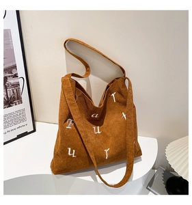 Détail du sac cabas en velours côtelé marron avec broderie de lettres et texture nervurée