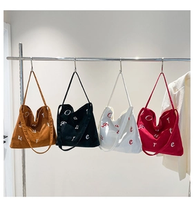 Vue détaillée de grands sacs cabas en velours côtelé brodés en quatre couleurs assorties