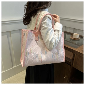 Détail de sac cabas rose avec broderies colorées dans un décor intérieur moderne épuré
