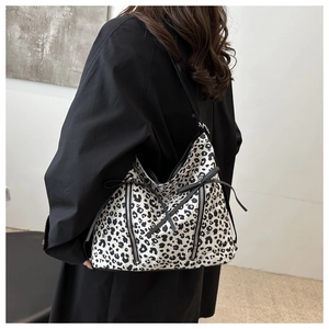 Dettaglio della grande borsa tote leopardata in bianco e nero con nastri e zip decorative