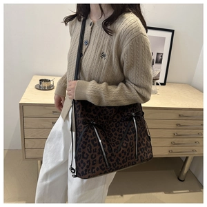 Dettaglio della borsa tote leopardata con cerniere argentate e piccoli fiocchi neri decorativi