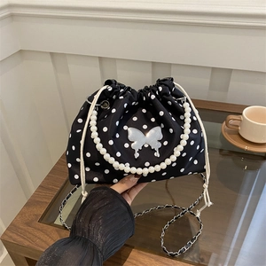 Polka dot drawstring bucket bag with pearl handle and silver butterfly ornament