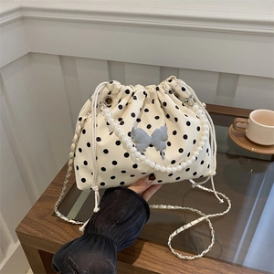 Polka dot drawstring bucket bag with pearl handle and silver butterfly charm