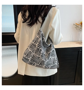 Vue portée du grand sac fourre-tout géométrique noir et blanc avec une bandoulière large
