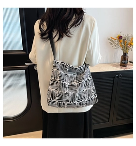 Détail d'un grand sac cabas en toile rayée noir et blanc avec une large bandoulière