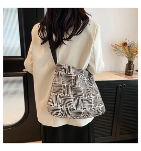 Détail d'un grand sac cabas en toile avec motif géométrique noir et blanc et bandoulière