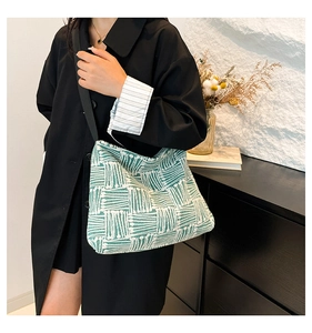 Détail du sac cabas en toile à motif géométrique vert et blanc avec texture de tissu