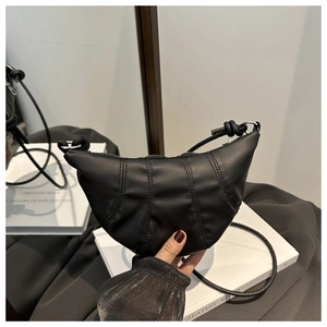 Detailed view of black matte leather croissant bag with stylish stitching and adjustable strap
