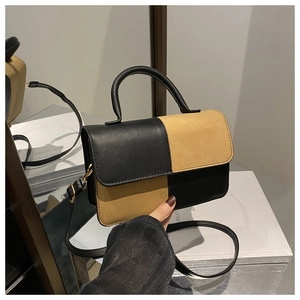 Detail view of the black and camel patchwork texture on the crossbody bag
