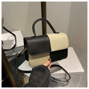 Detailed view of the black and white checkerboard leather handbag with crossbody strap