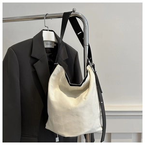 Detail der minimalistischen cremefarbenen Canvas-Beuteltasche mit hochwertiger Metallkette
