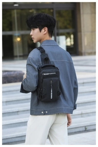 Detail of black waterproof crossbody bag with adjustable strap on urban male model