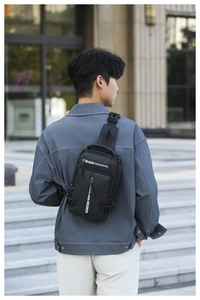 Close-up of durable black nylon sling bag featuring multiple zip compartments and padded strap