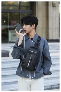 Detail of waterproof crossbody chest bag with integrated USB charging port for men
