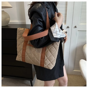 Détail d'un grand sac cabas matelassé avec motif à losanges et fermeture aimantée