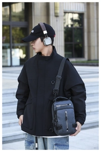 Close-up of gray multi-pocket tactical chest bag with adjustable strap on male model