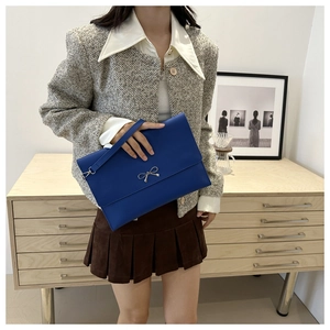 Λεπτομέρεια του βασιλικού μπλε φακέλου clutch με μεταλλικό φιόγκο και λουράκι καρπού