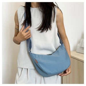 Detailed side view of the Morandi blue crescent crossbody bag with adjustable wide strap