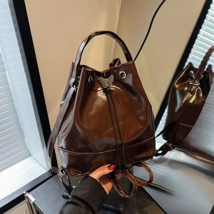 Sac à dos seau marron foncé brillant avec fermeture à cordon et boucle papillon métal