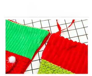 Detail of corduroy Christmas stockings with red and green stripes and white pom-poms