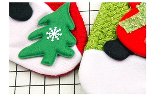 Detail of Christmas stocking with green felt tree, snowflake patterns, and red textured fabric