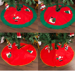 Close-up of red Christmas tree skirt with festive Santa and snowman applique embroidery