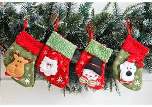 Set di 4 calze natalizie con Babbo Natale e Renna 3D appese ai rami di pino