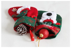 Detail of red Santa and green Polar Bear Christmas stockings with felt dolls and holly berries