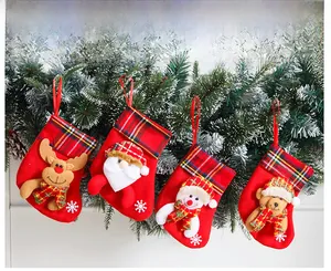 Hanging Christmas stocking set with reindeer snowman and santa on snowy tree branch