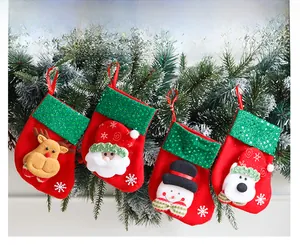 Detail of four Christmas stockings with sequins, Santa and reindeer on pine branches