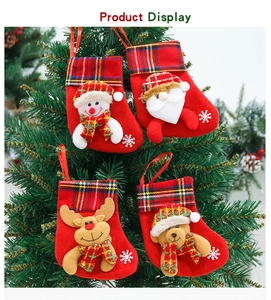 Close-up of four plush Christmas stockings featuring Santa and Reindeer hanging on a tree